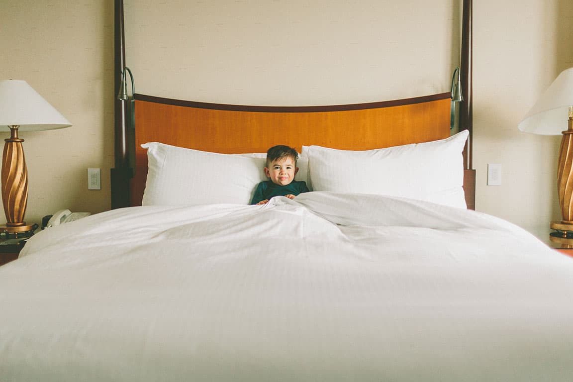 Mom and son sharing hotel bed