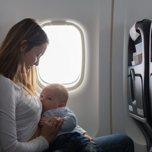 Mother breastfeeding on a plane with baby