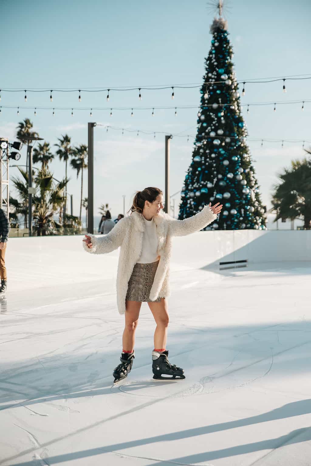 Ice skater twirling at the Ice Rink at Pasea Hotel and Spa in Huntington Beach CA during Christmas