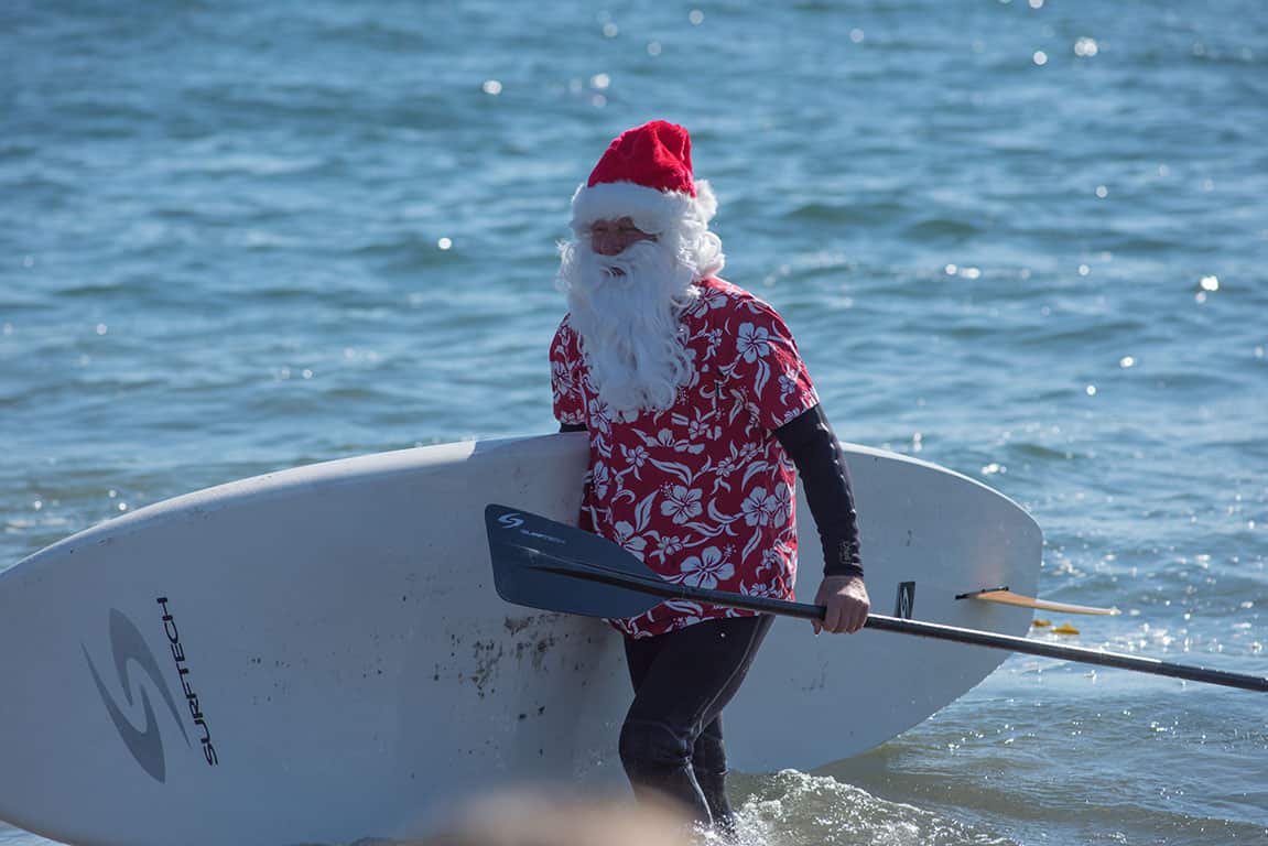 Surfing Santa during Christmas in Santa Cruz California