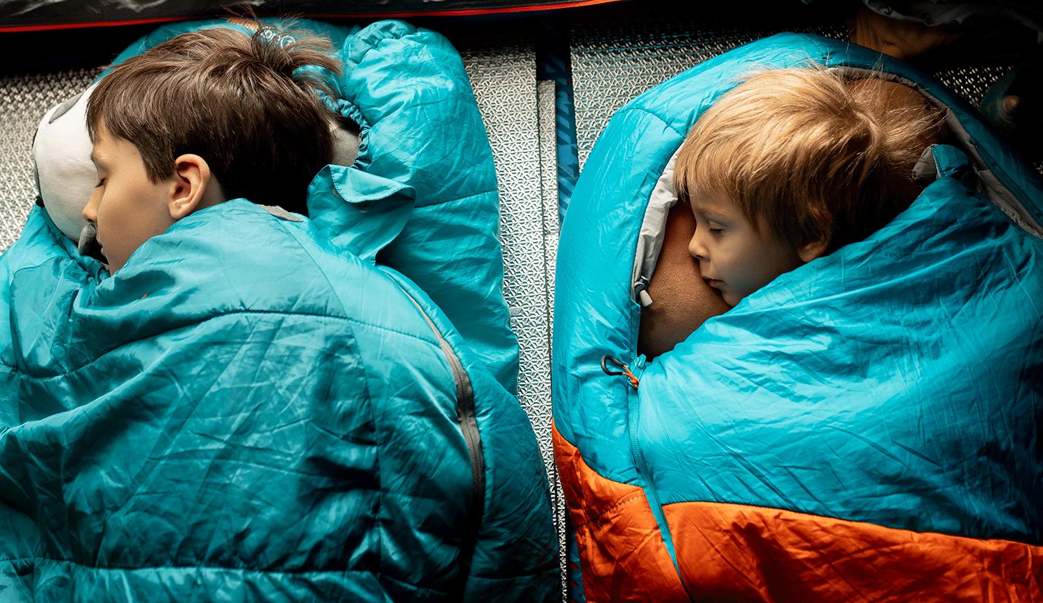 17 Years of Family Travel Taught Us Every Trick for Fitting 4 People in a Hotel Room 8 Kids sleeping in sleeping bags on the floor